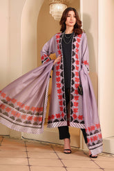 Woman wearing a light purple dress with floral patterns in an elegant interior setting.